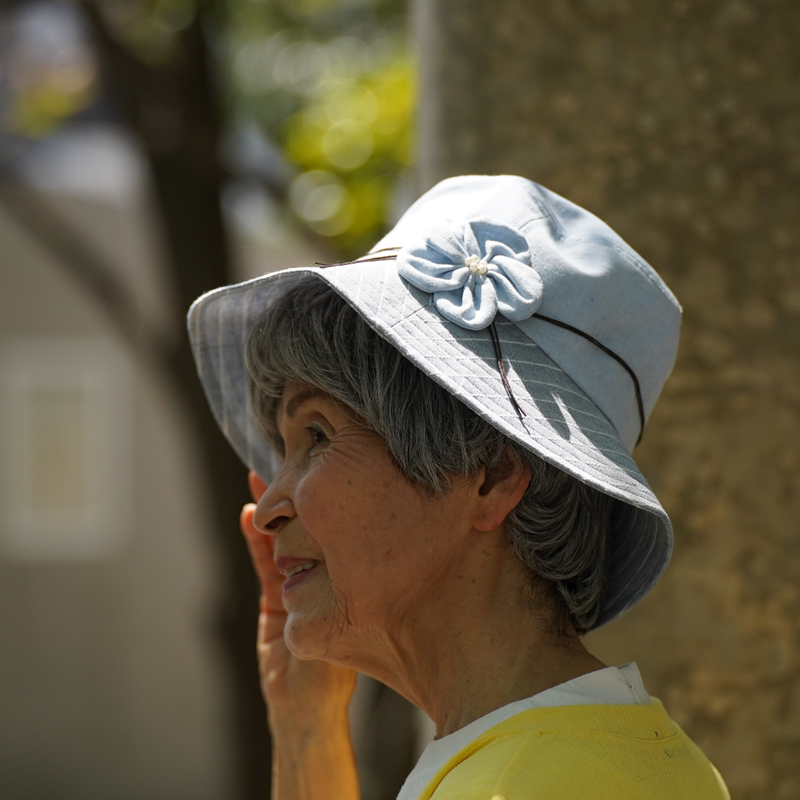 花モチーフのついた帽子をかぶるシニア女性
