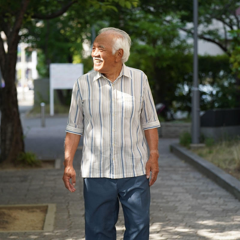 シニアファッションのシャツきて歩く高齢者男性